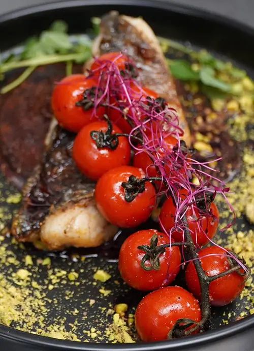 Cherry tomatoes on top of meat.